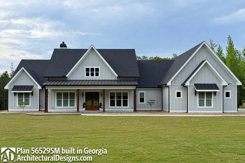 Modern Farmhouse exterior with board and batten siding, prominent gables, deep eaves, and a covered porch with wooden columns.